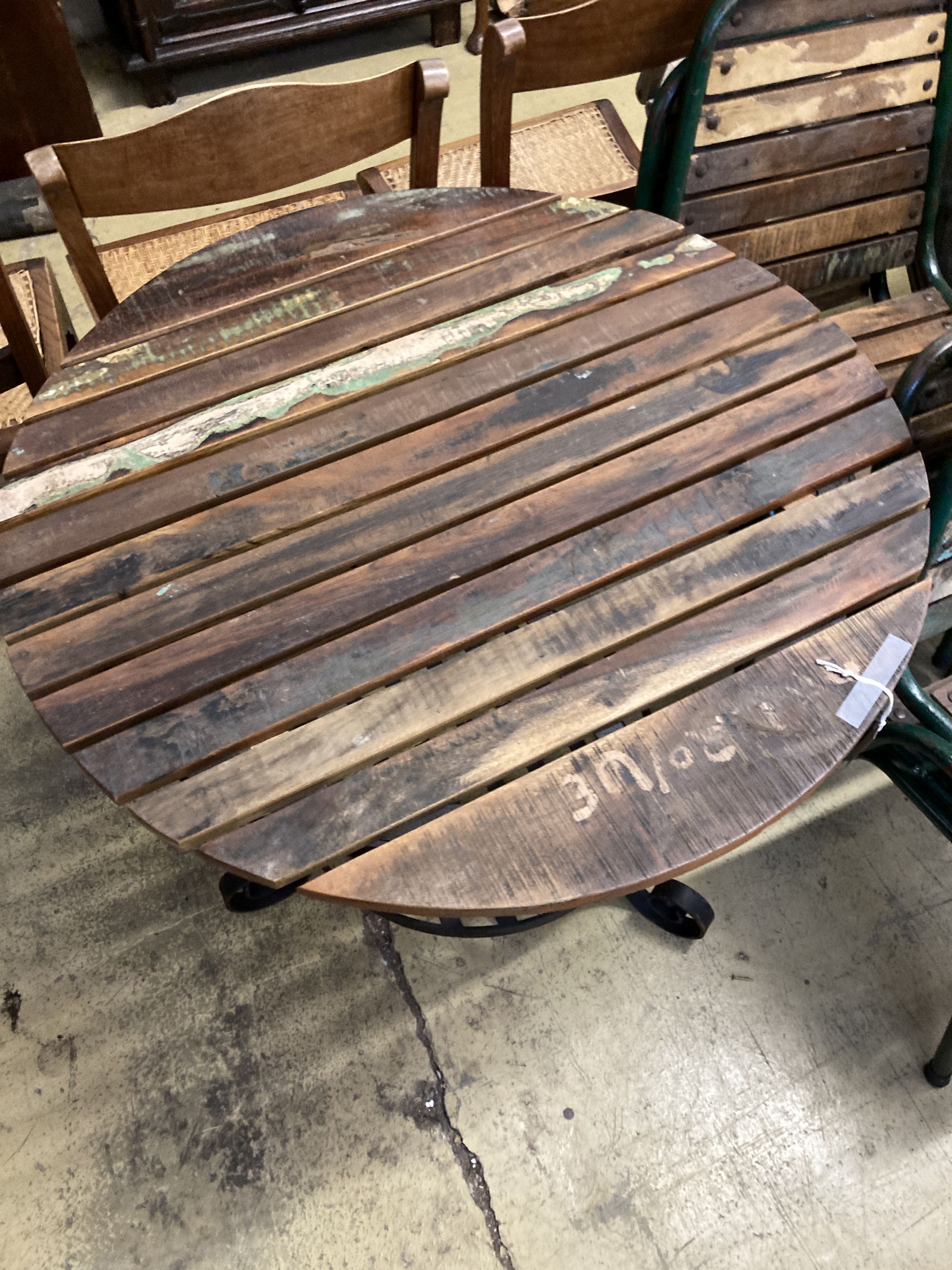 A circular slatted wood and wrought iron garden table, 85cm diameter, height 78cm together with a set of four slatted metal stacking ga